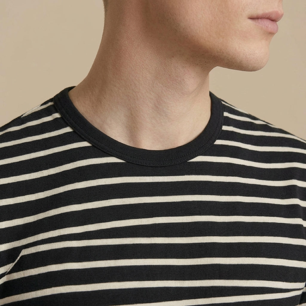 Close-up of the washed black cotton fabric and striped design on a men's T-shirt