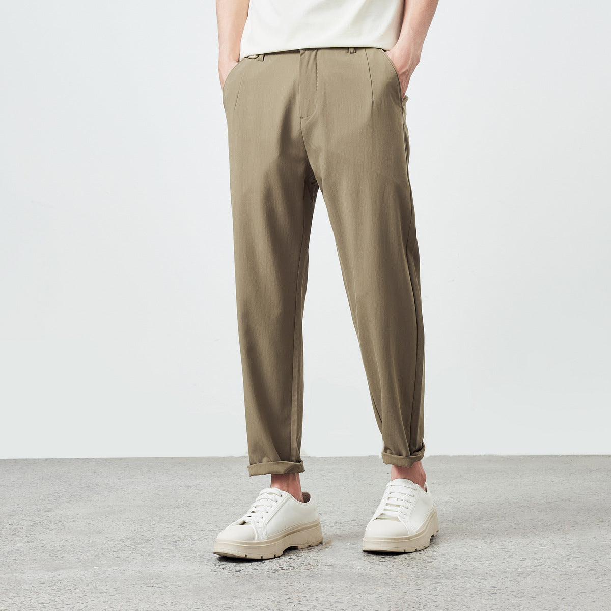 Men's pleated tapered pants in khaki brown shown from the front