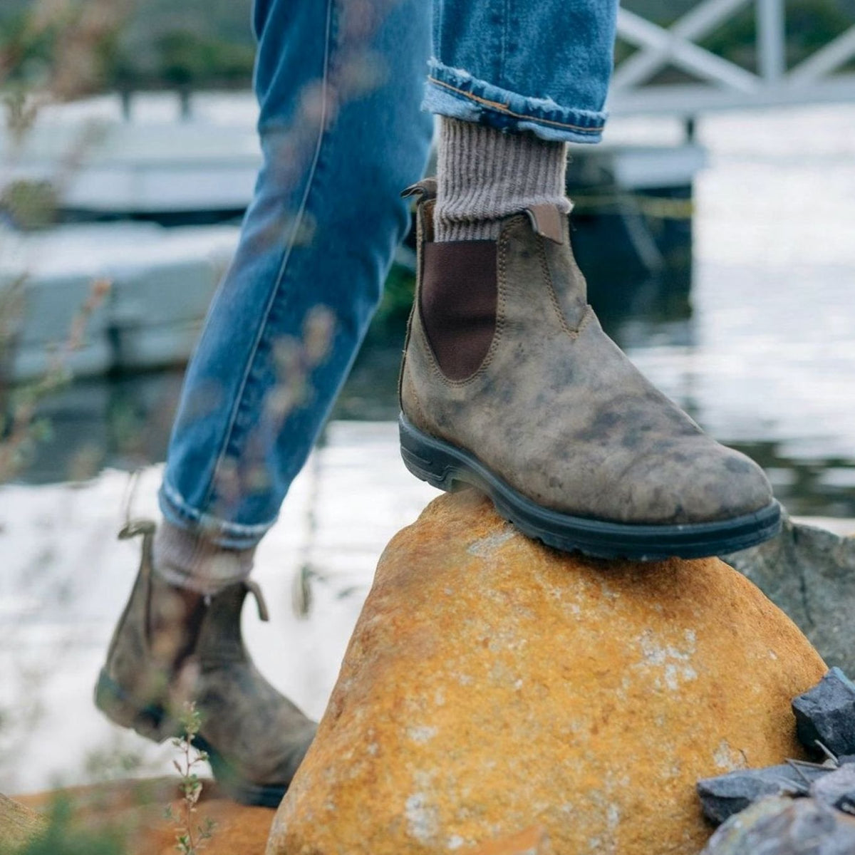 Men's leather Chelsea boots shown from the side with elastic panels and pull tabs