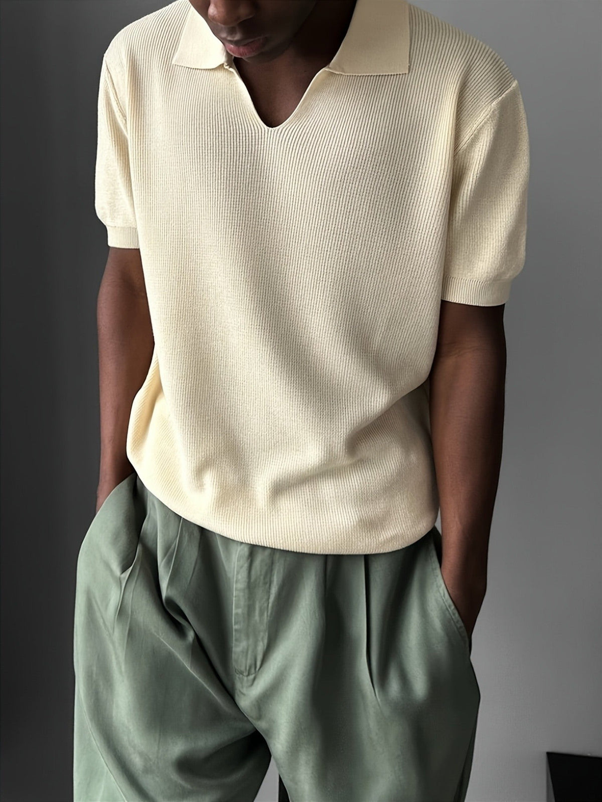 Front view of a men's ribbed polo shirt with a relaxed open V-neck