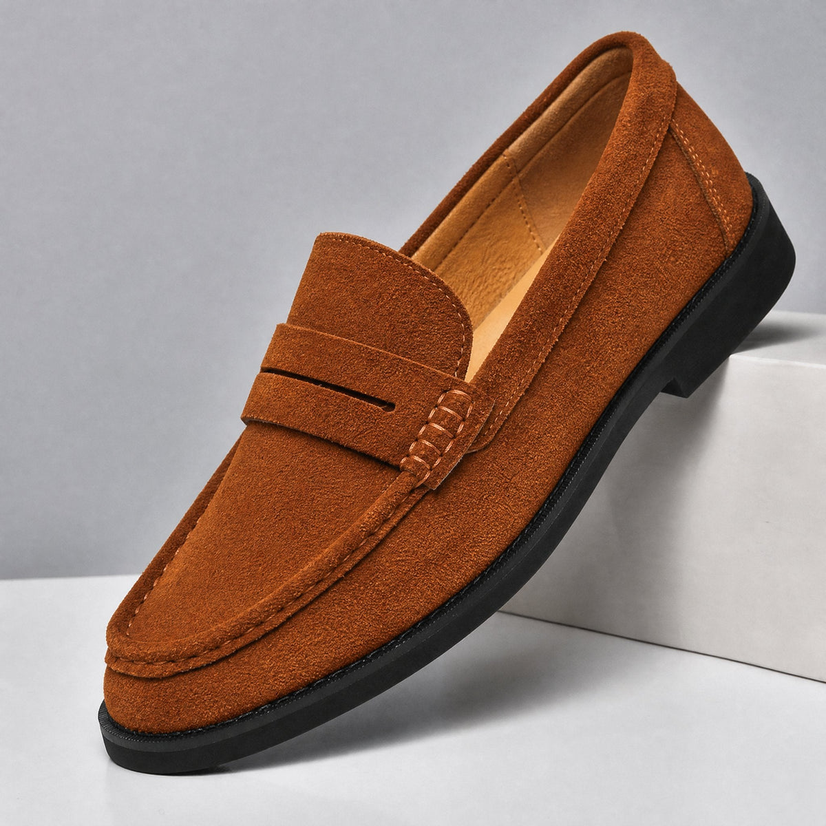 Men's suede penny loafers shown from the side