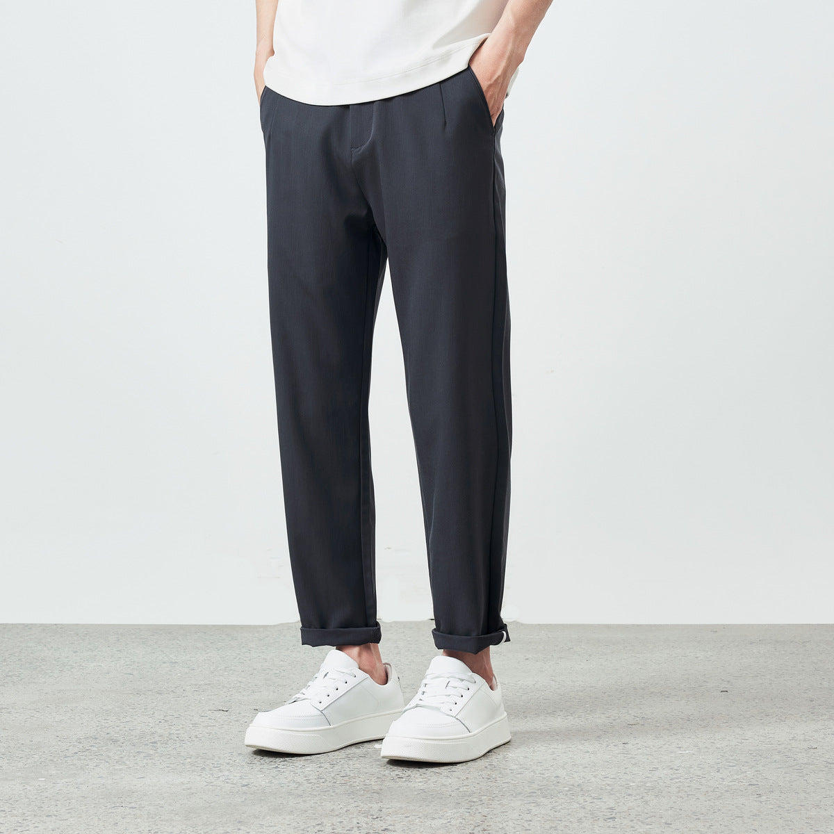 Close-up of pleated khaki brown pants with front pockets
