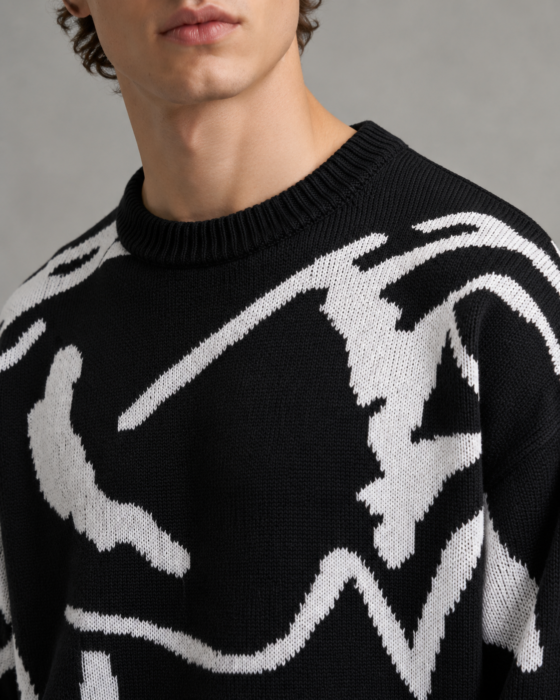 Detail view of the textured knit fabric on an abstract graphic sweater.