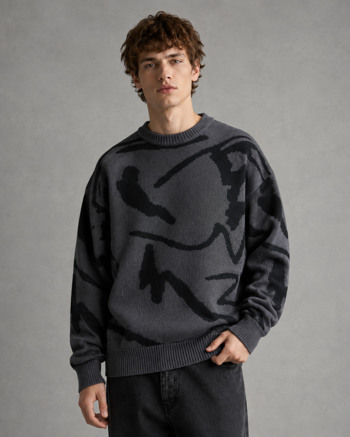 Full view of the relaxed-fit men's sweater with an abstract graphic design.