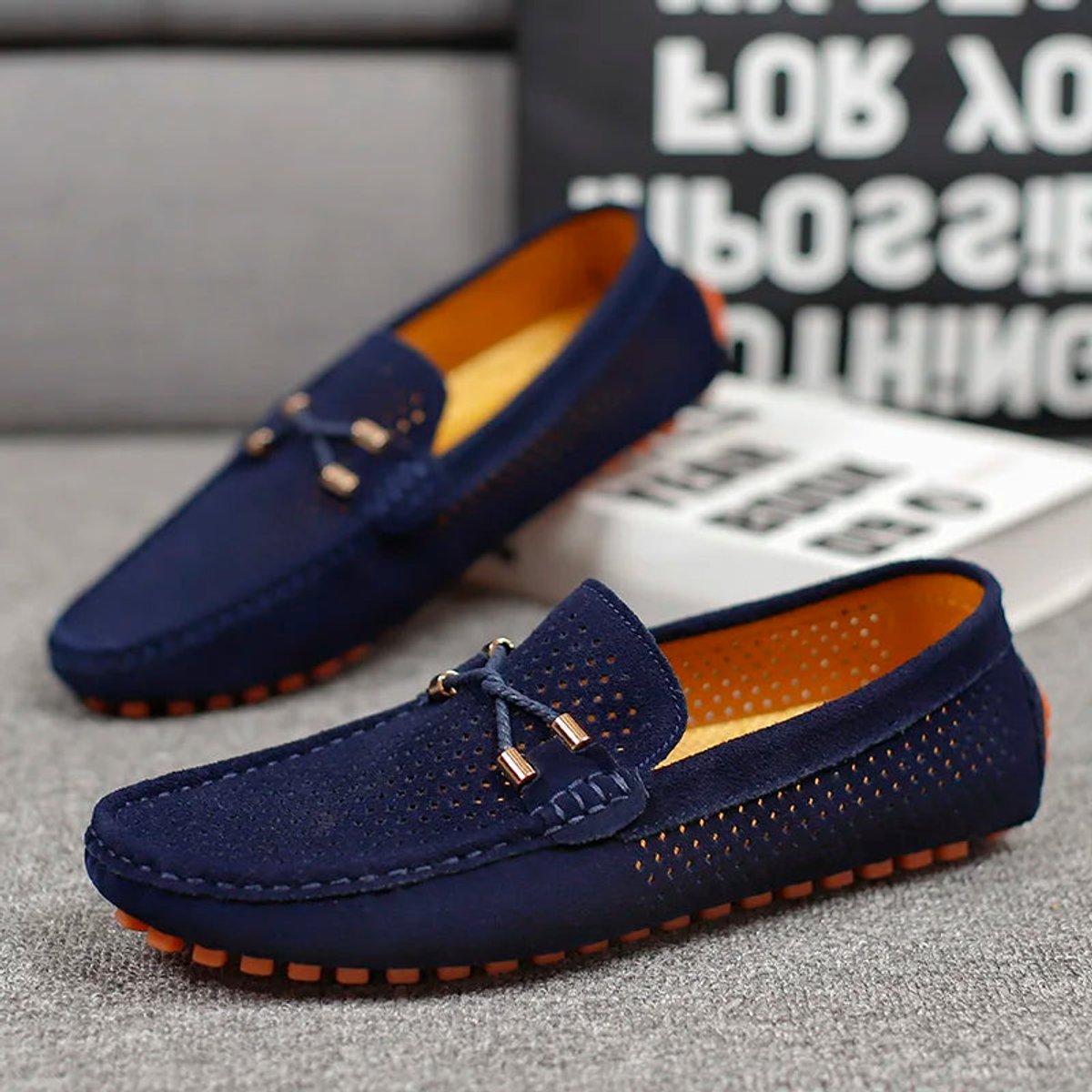 Men's perforated suede driving loafers arranged as a complete pair