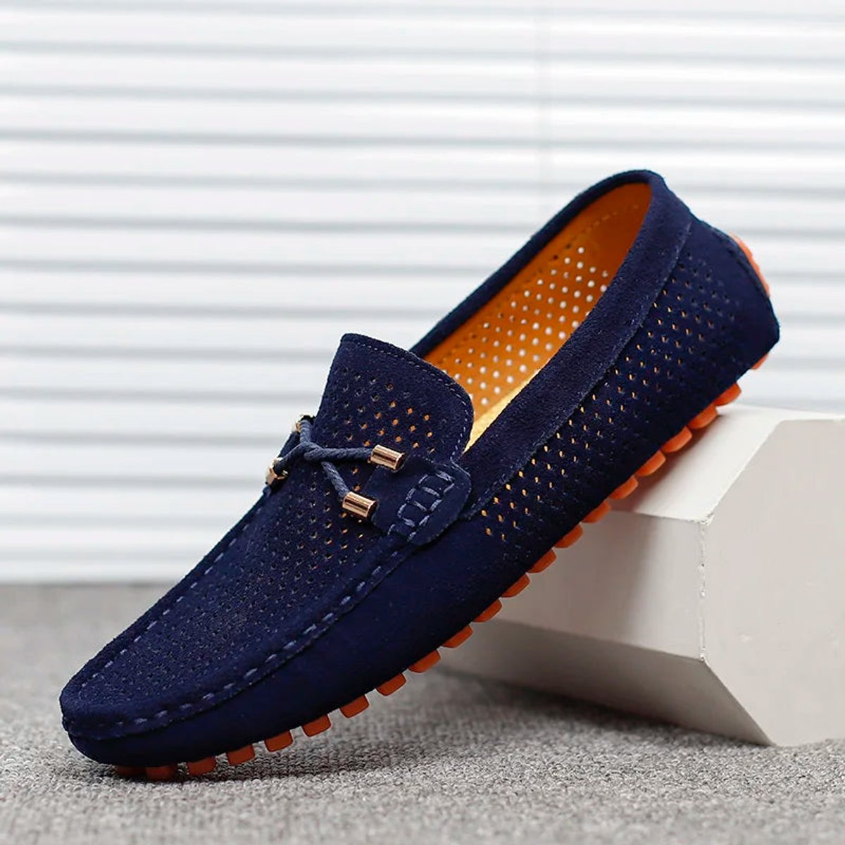 Men's perforated suede loafer showing the rounded toe shape