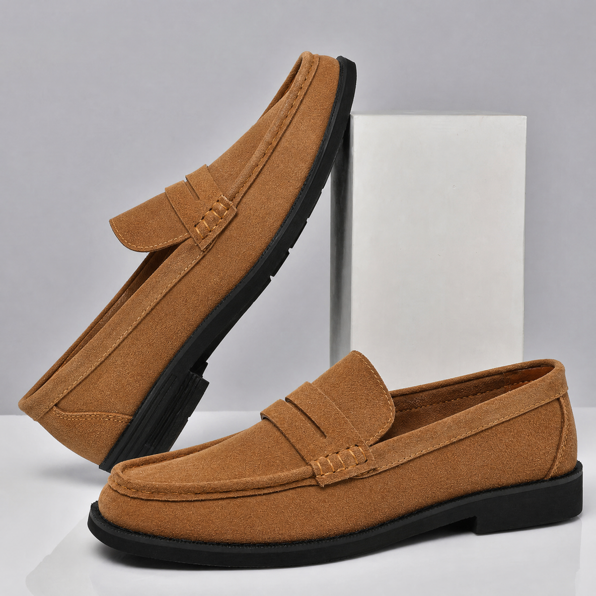 Men's suede penny loafers displayed as a pair