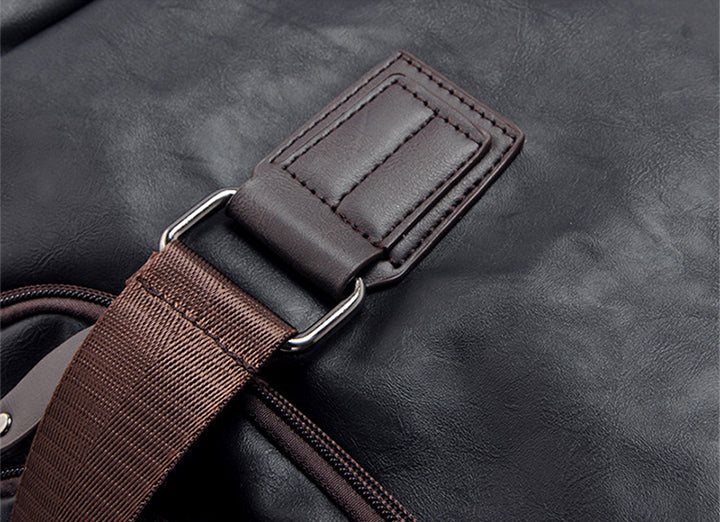 Angled view of the leather weekender bag with carry handles and detachable shoulder strap